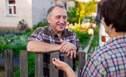 Picture of neighbours talking to each other over the fence.